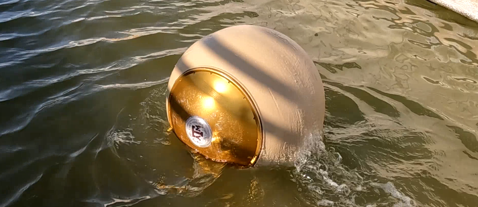 A spherical ball robot, Roboball, operating in water. The ball is floating on the surface and has a trail indicating forward motion.